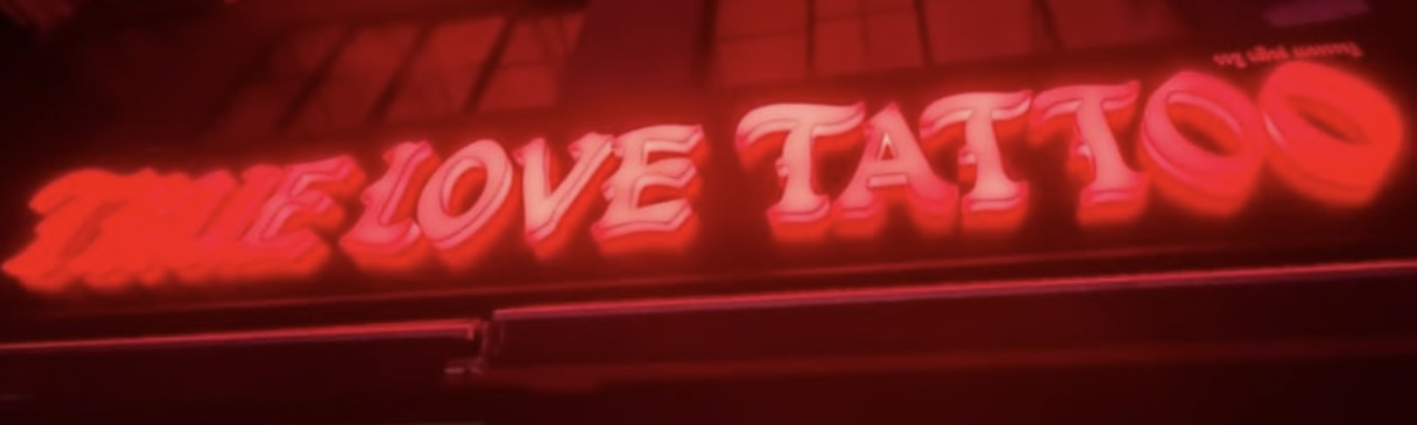 True Love Tattoo neon sign glowing red at night